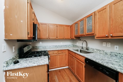 A kitchen with wooden cabinets and granite countertops.
