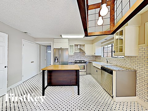 A kitchen with a black and white floor.