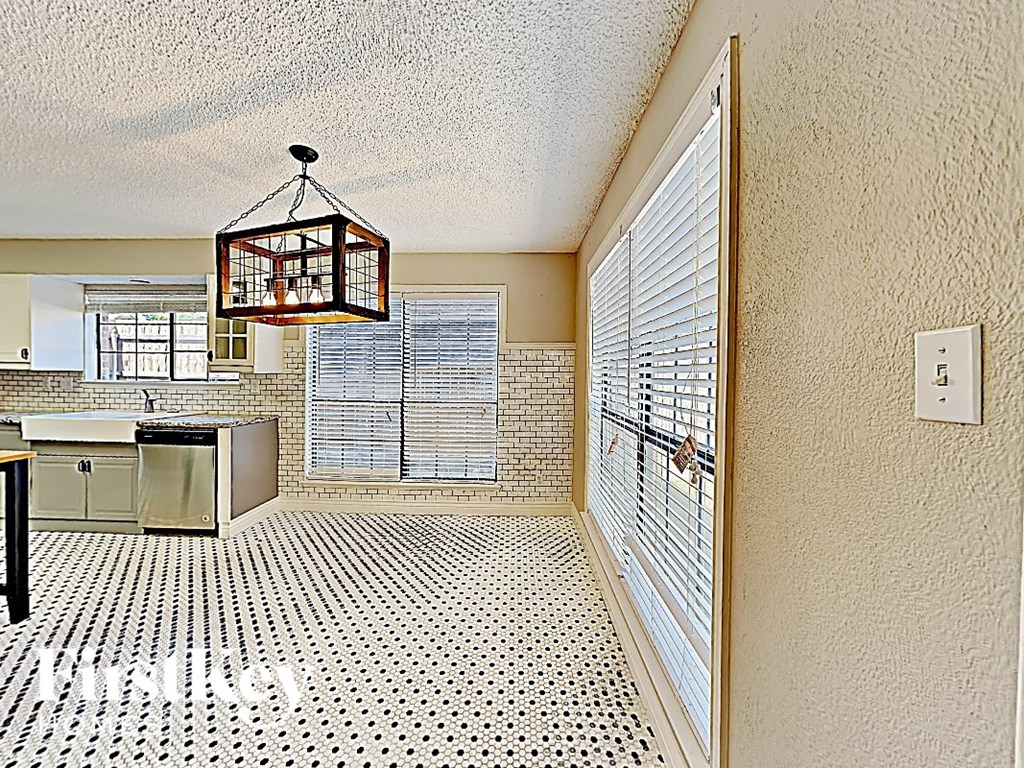 A kitchen with a black and white floor.
