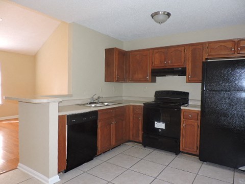 A kitchen with black appliances and wooden cabinets.