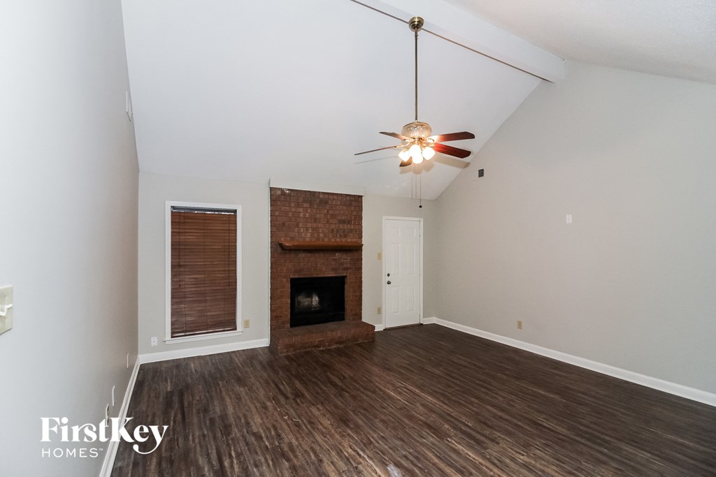 a living room with a fireplace and a ceiling fan
