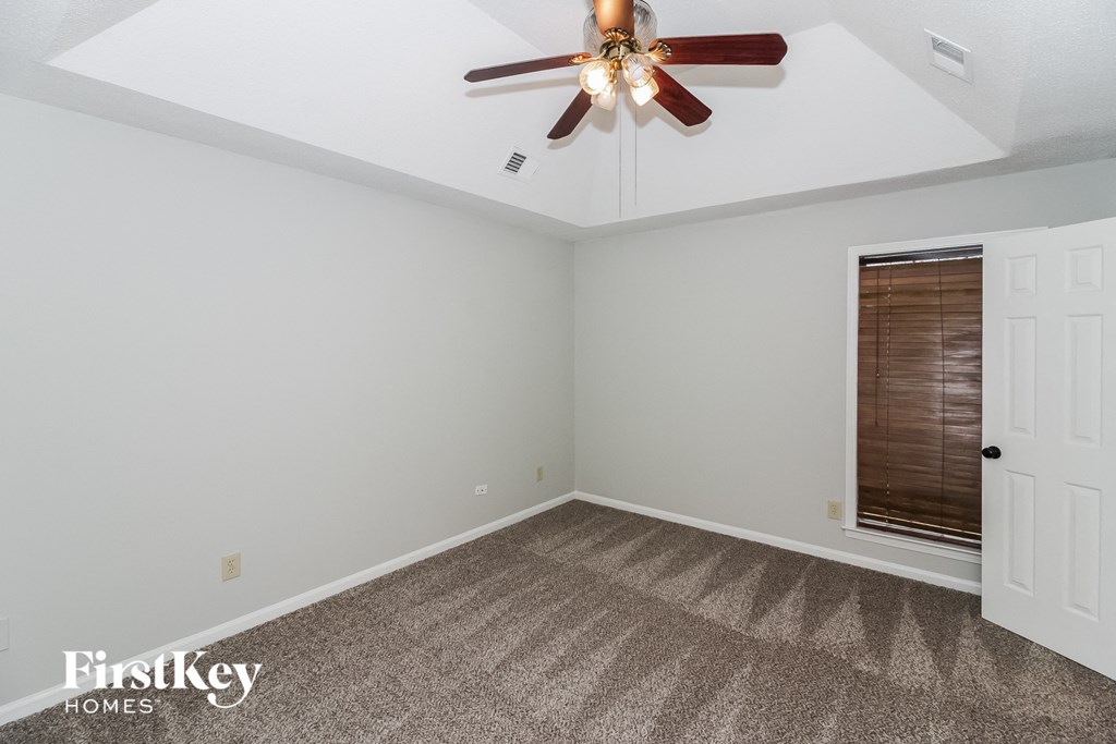 the living room of an empty house with a ceiling fan