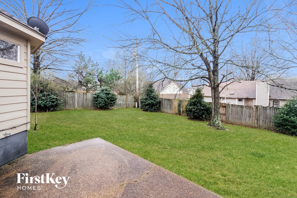 the backyard of a house with a yard and a fence