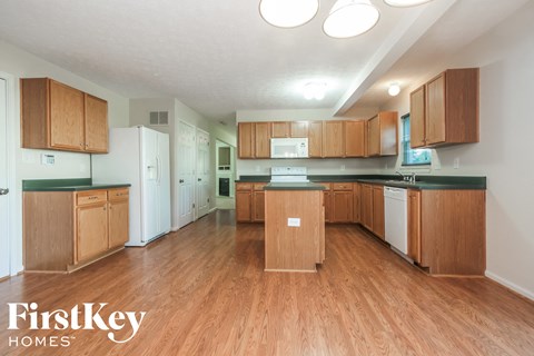 A kitchen with wooden cabinets and a white fridge.