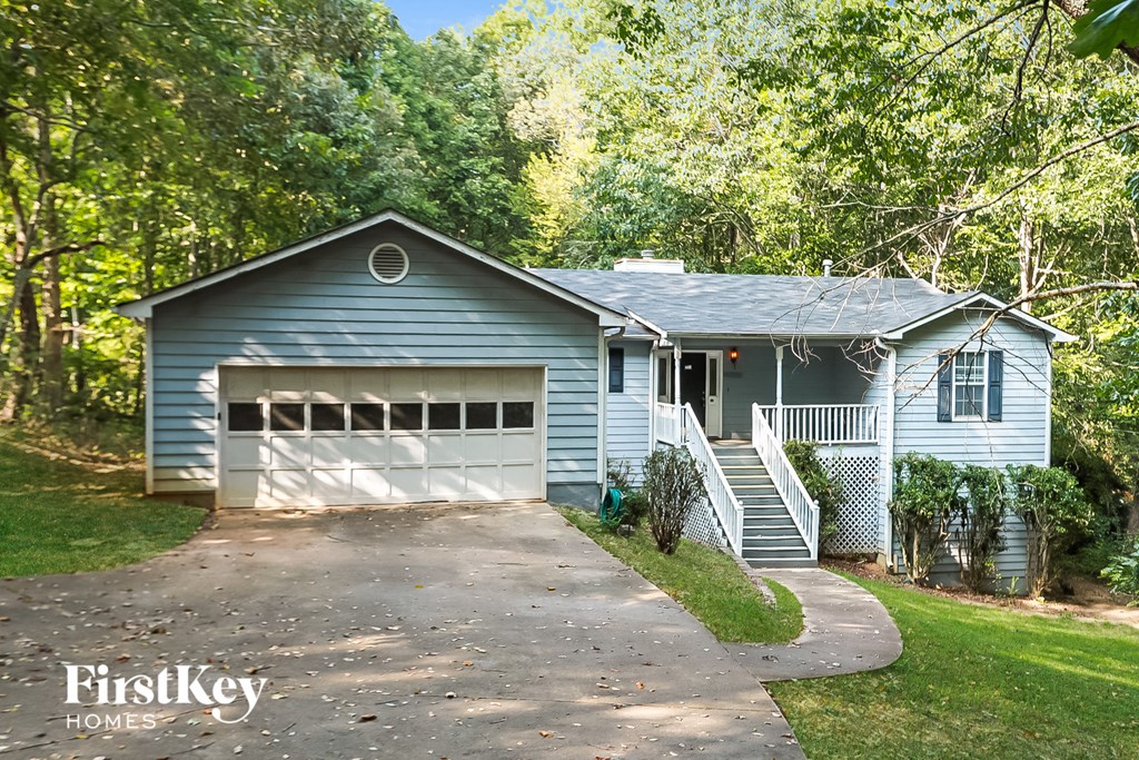 a blue house with a driveway and a garage door
