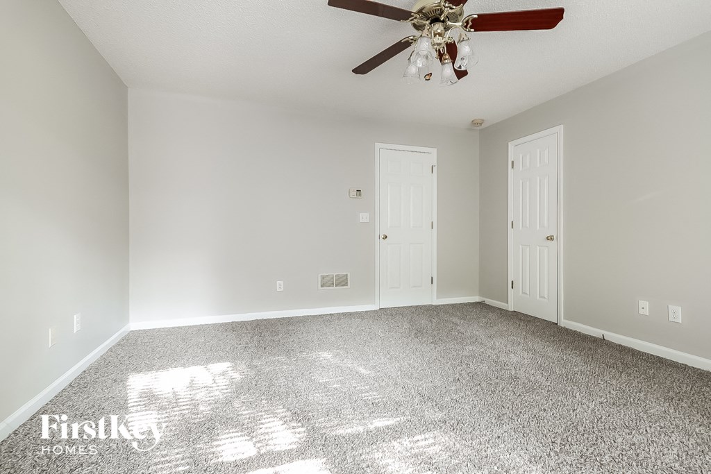 a empty room with a ceiling fan and a white door