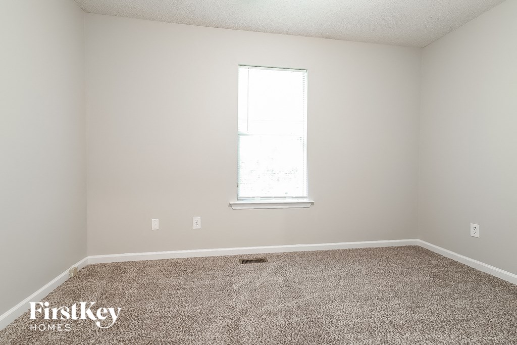 a empty room with carpet and a window