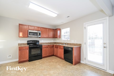 a kitchen with wood cabinets and black appliances and a window