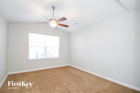 a bedroom with a ceiling fan and a window