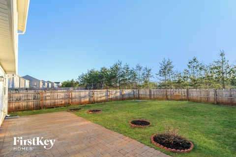 a backyard with a wooden fence and a lawn