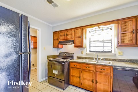 A kitchen with wooden cabinets and a stainless steel refrigerator.