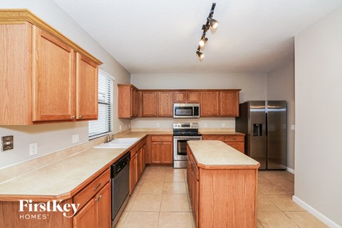 a large kitchen with wooden cabinets and stainless steel appliances