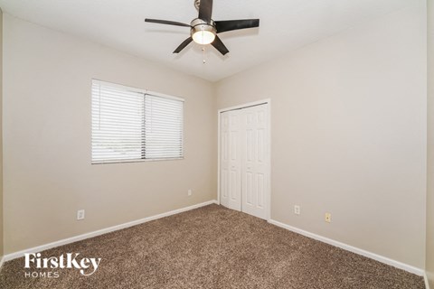 a bedroom with a ceiling fan and a window