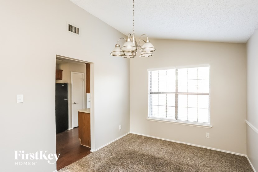 A room with a carpeted floor and a window with blinds.
