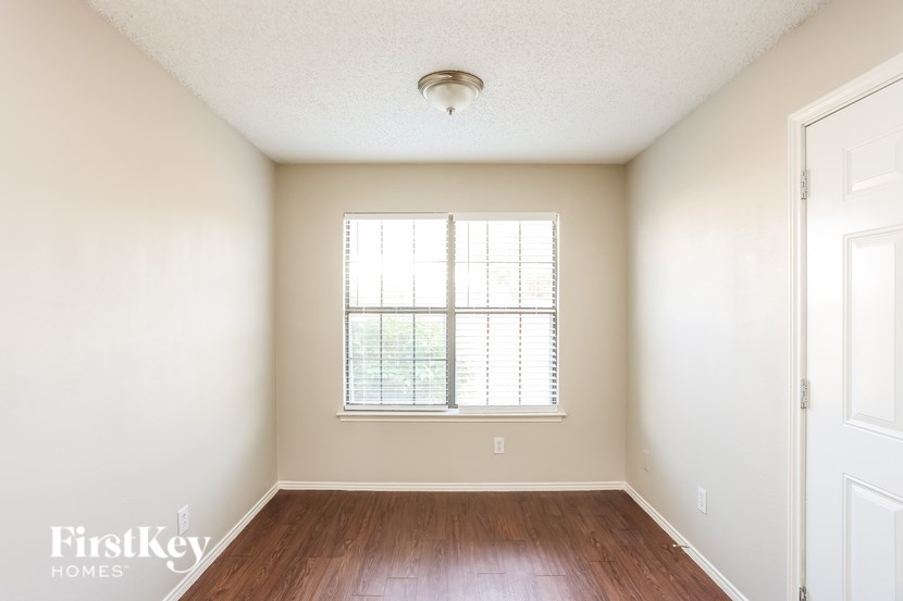 A room with a window and wooden floors.
