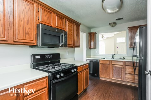 A kitchen with wooden cabinets and a black stove top oven.