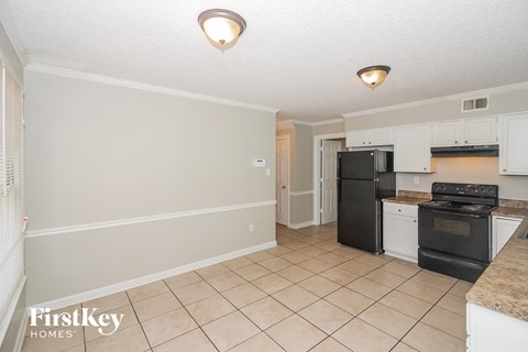 A kitchen with black appliances and white cabinets.