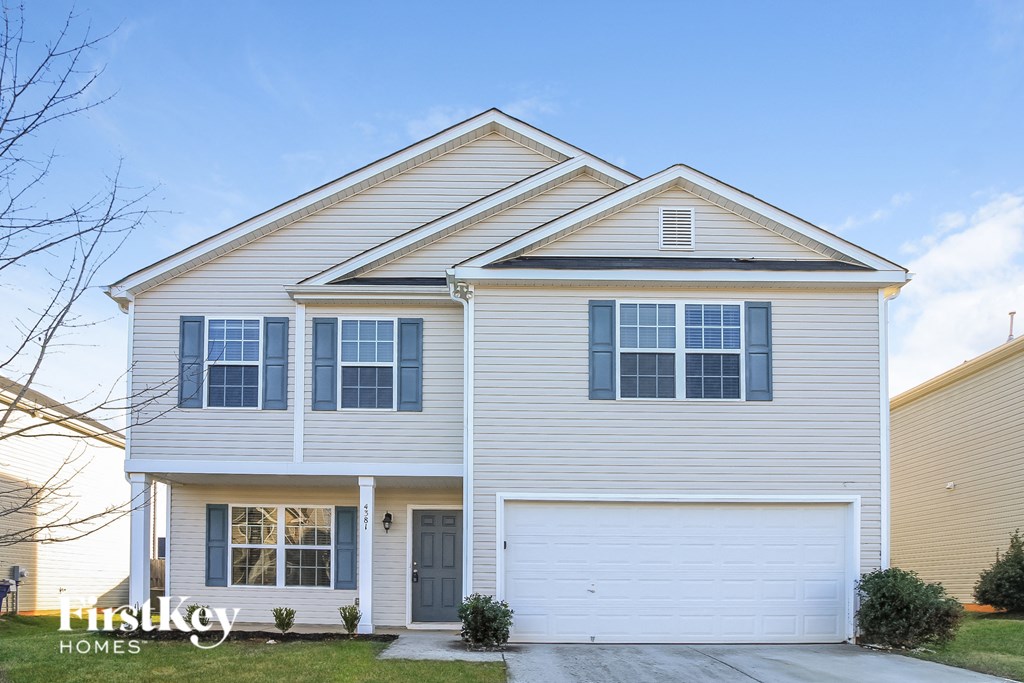 a white house with white siding and a driveway