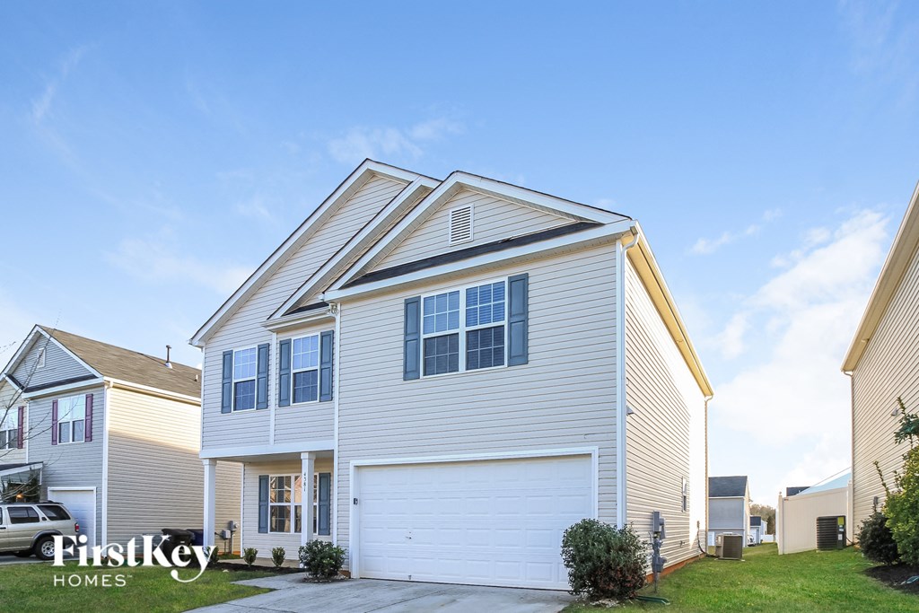 a white house with a white garage door and a lawn