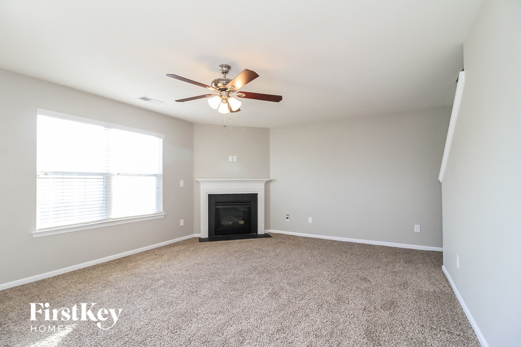 a living room with a ceiling fan and a fireplace