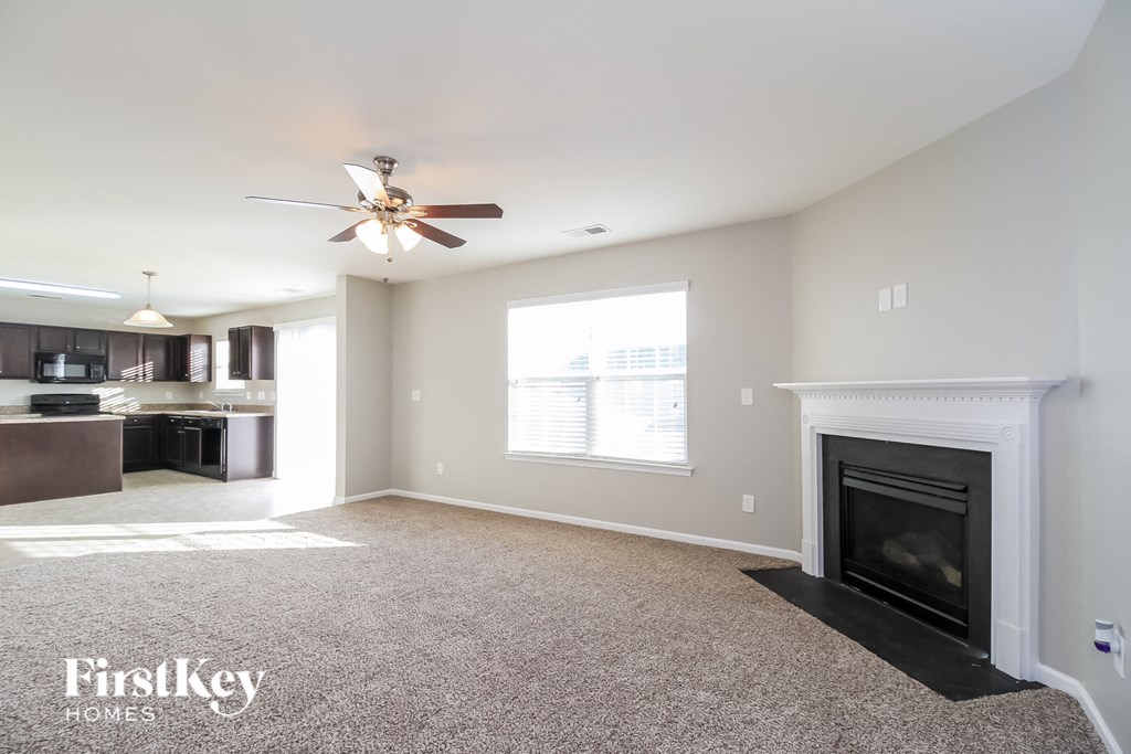 a living room with a fireplace and a ceiling fan