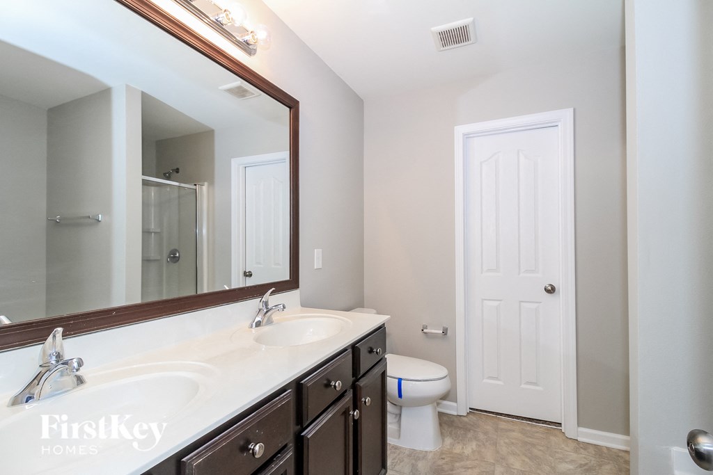 a bathroom with a large mirror and a toilet and a sink