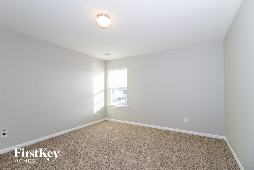 a spacious room with carpet and a window