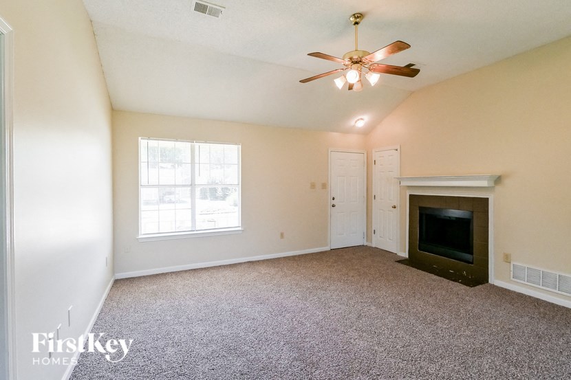 a living room with a fireplace and a ceiling fan