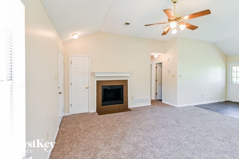 a living room with a fireplace and a ceiling fan