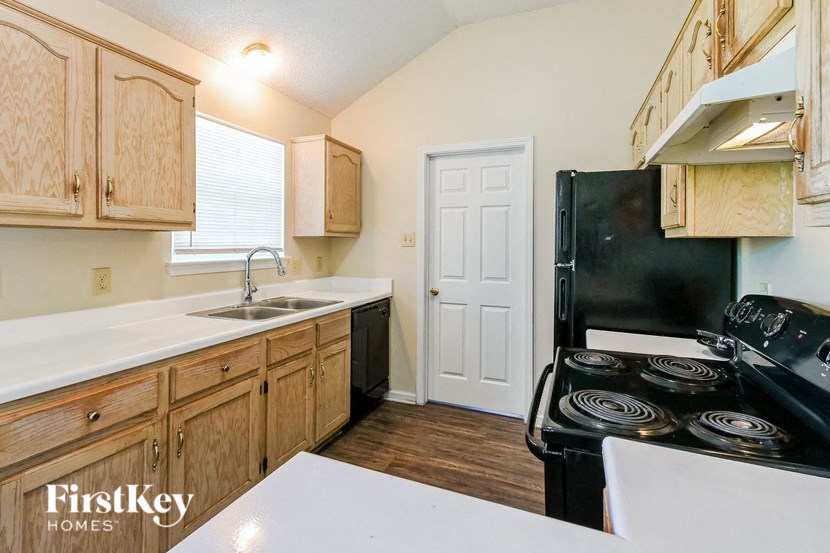 a kitchen with a stove refrigerator and sink