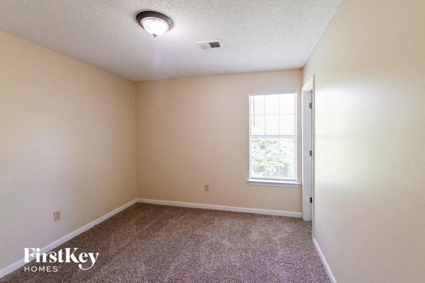 an empty room with carpet and a window