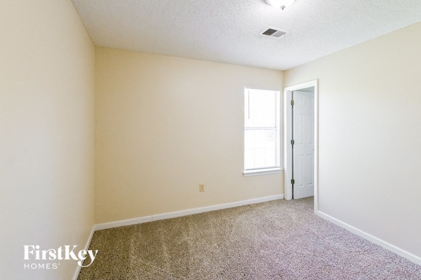 a bedroom with carpet and a door to a closet