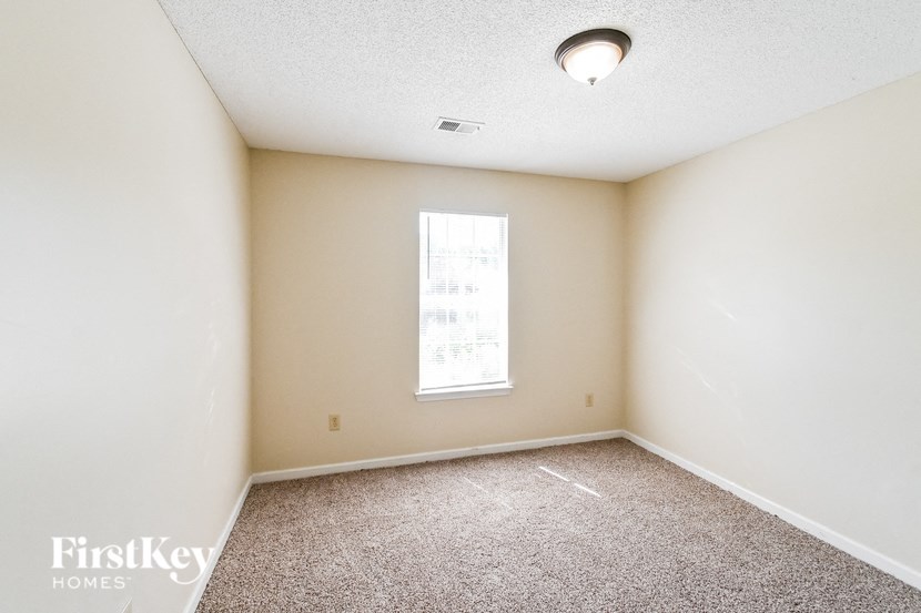 an empty room with carpet and a window