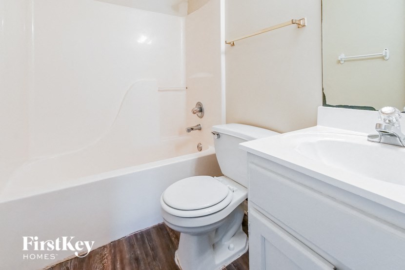 a white bathroom with a toilet and a sink
