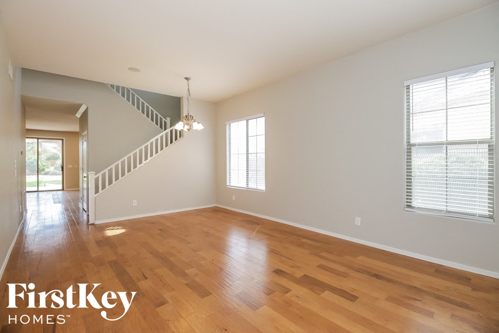 an empty living room with wood floors and a staircase