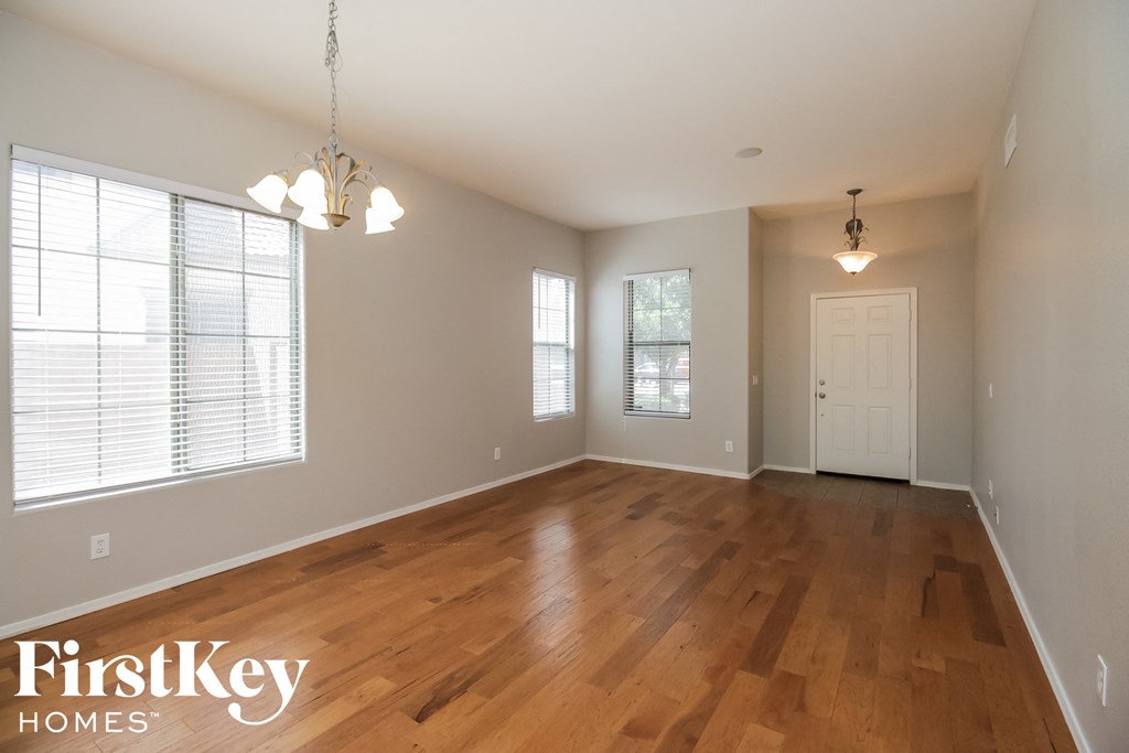 an empty living room with wood floors and a white door