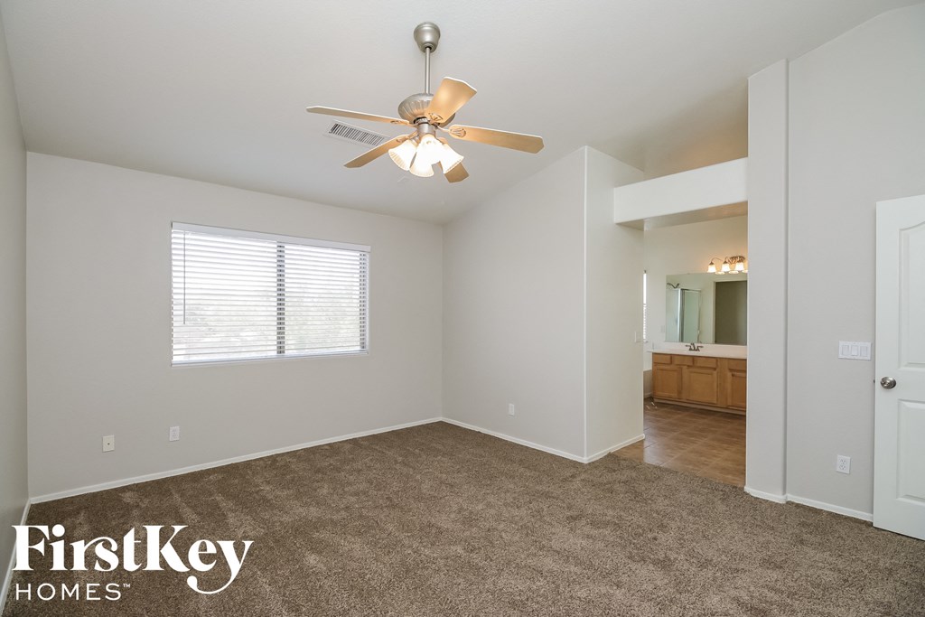 a living room with carpet and a ceiling fan