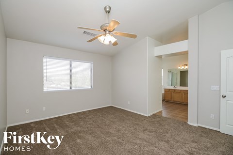 a living room with carpet and a ceiling fan