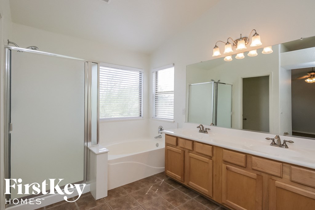 a white bathroom with two sinks and a tub and a shower