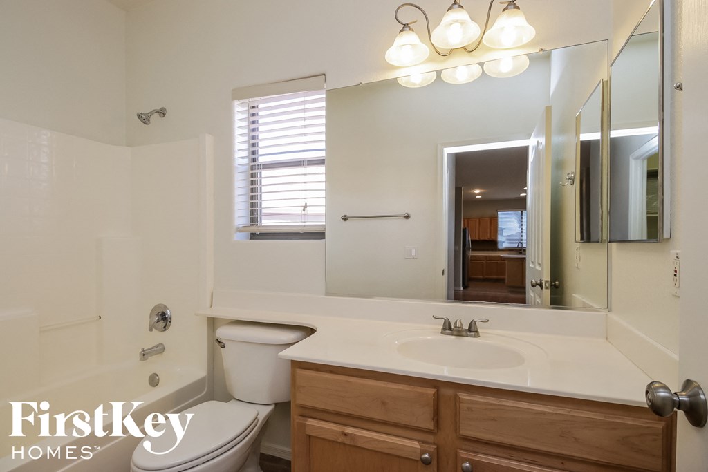 a bathroom with a large mirror and a sink and a toilet