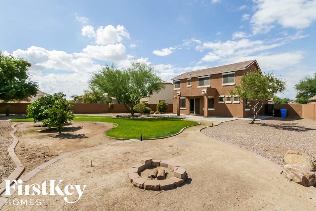 a backyard with a fire pit and a house