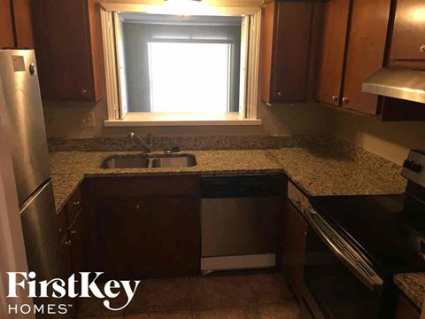 A kitchen with a granite countertop and a window.