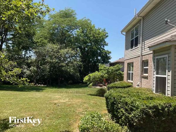 A house with a lawn and trees in the background.