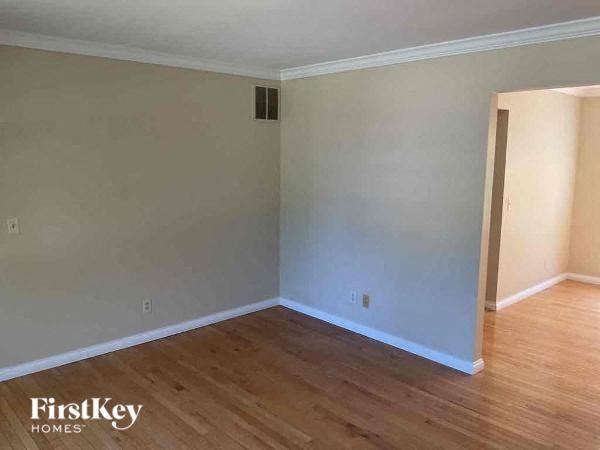 A room with wooden flooring and a white wall.