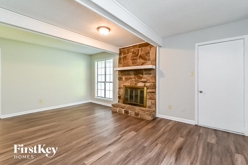 a living room with a fireplace and wooden floors