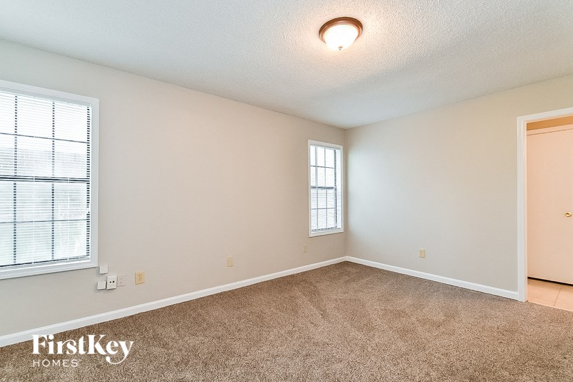 an empty living room with a window and a door