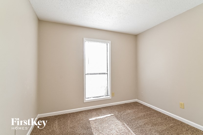 an empty room with a window and carpet