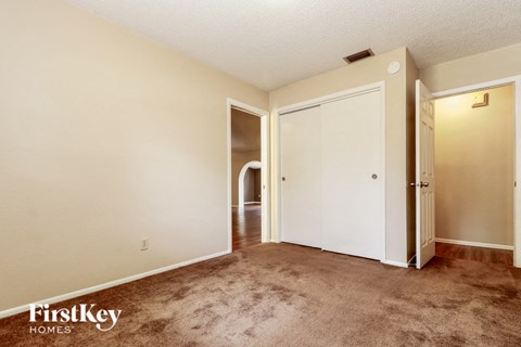 a living room with carpet and a door to a hallway