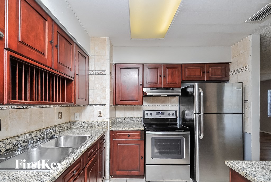 A kitchen with wooden cabinets and stainless steel appliances.