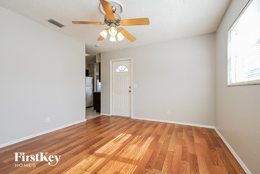 A room with a wooden floor and a ceiling fan.